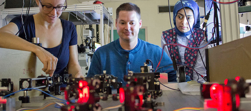 Associate Professor Keith Lidke works at optics table with students